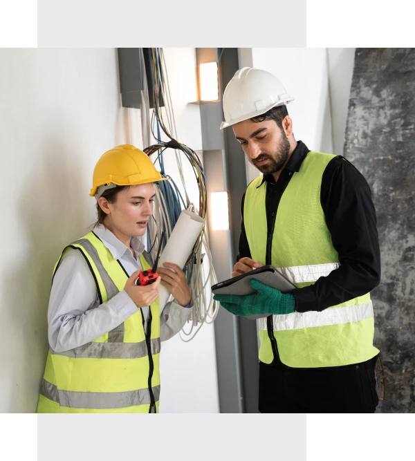 Workers in safety gear examining blueprints