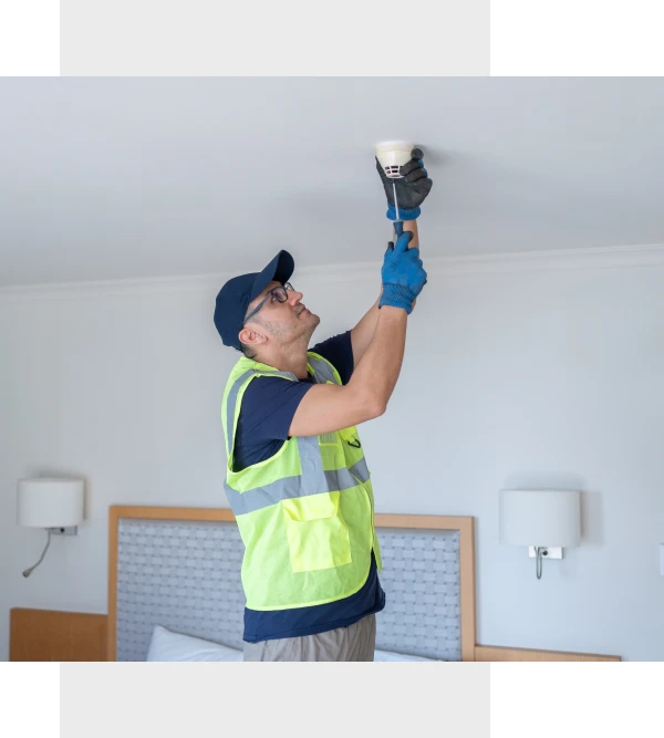 Technician fixing a smoke alarm