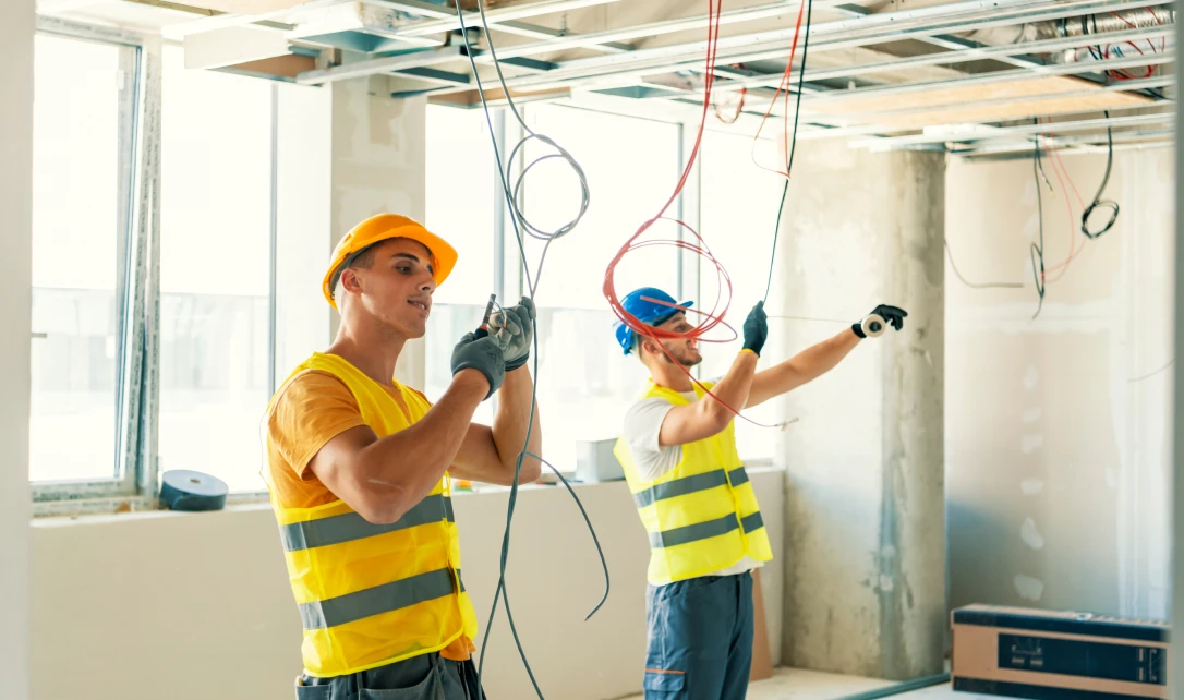 Workers in safety gear handling wires